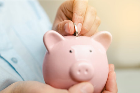 Female hands putting coins into piggy bank. Business or finance saving show putting coin saving and...