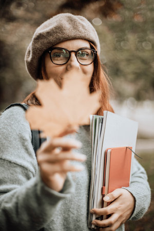 Portrait of young happy student looking and smile at camera in a park. Working, freelancing, studying, educationの写真素材