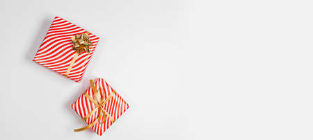 Gift box with gold ribbon on white background. Birthday party, Valentines day or mothers day greeting card. Top view, flat lay, copy spaceの写真素材