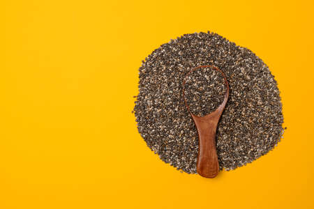 Wood spoon with chia seed son a yellow background with copy space, closeupの写真素材