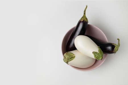 Plate with raw ripe colour eggplants with copy space on grey background. Top view. Harvest conceptの写真素材
