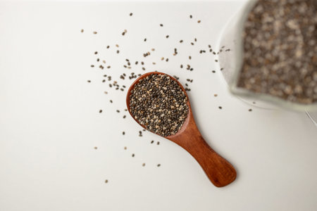 Chia seeds in wooden spoon and cup from top view with space on white background with copy space, view from aboveの写真素材