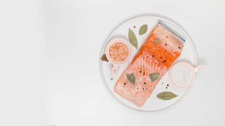 Fresh orange salted piece on a white plate with copy space, gray background.の写真素材