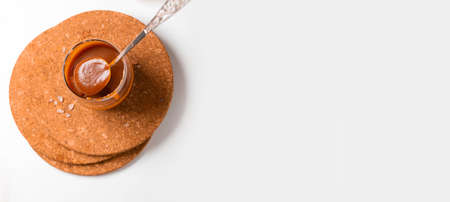 Homemade salted caramel in a glass jar. Delicious sauce with sea salt for ice cream and desserts View from aboveの写真素材