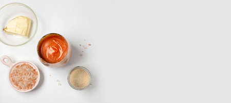 Homemade salted caramel in a glass jar. Delicious sauce with sea salt for ice cream and dessert on white backgroundの写真素材