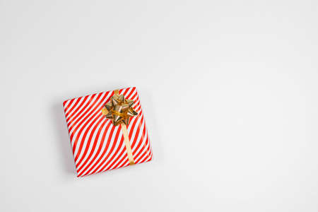 Christmas composition. Gift box with gold ribbon on white background. Christmas and New Year holiday background. Top view, flat lay, copy spaceの写真素材