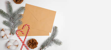 New year mail envelope craft paper for text on a white background with Christmas decor. A letter to Santa Claus, a wish list. Flat lay, copy spaceの写真素材