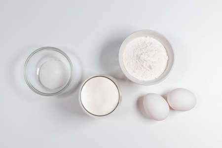 Baking homemade bread on white kitchen worktop with ingredients for cooking, culinary background, copy space, overhead viewの写真素材