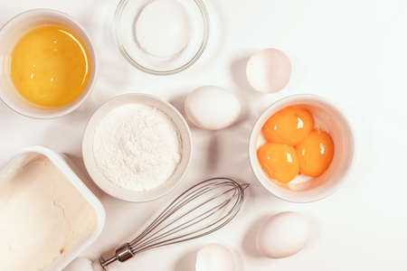 Baking utensils and cooking ingredients for tarts, cookies, dough and pastry. Flat lay with eggs, flour, sugarの写真素材