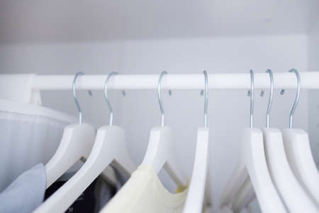 Women clothes hanging on wooden hangers in the closetの写真素材