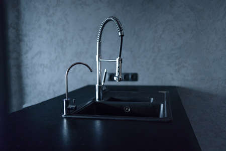 Sink and silver faucet on modern black kitchenの写真素材