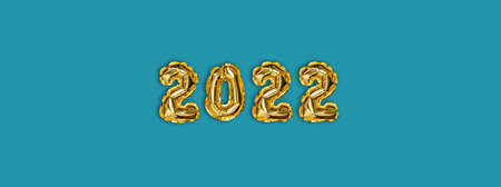 2022 golden foil balloons decor and Christmas snow with copy space on blue background. New Year conceptの写真素材