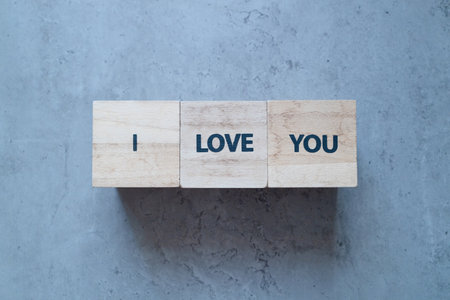 I love you more stamp letters text on wood blocks on the old concrete backgroundの写真素材