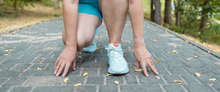 Cropped image of sport runner woman preparing for a low start run. Ready to run.