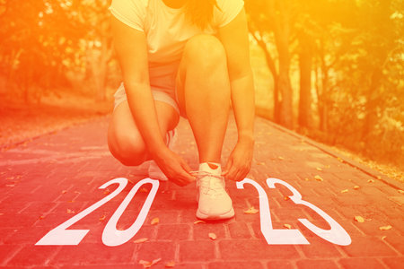 Cropped image of sports women hands tying laces off white sneakers outdoor for the run training, healthy exercise workout concept. Idea and creative in 2022の写真素材