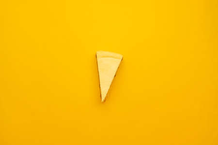 Piece of tasty cream cheesecake on yellow backgroundの写真素材