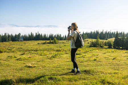 Photographer takes a photo on the top of the mountain. Amazing Carpathians landscape background...