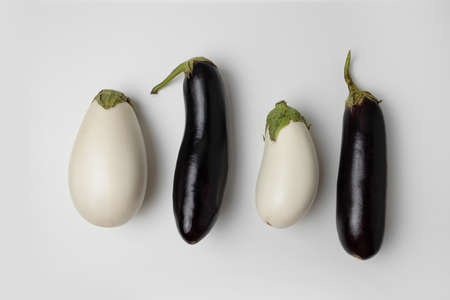 Raw ripe white and black color eggplants on gray background, top view. healthy diet vegetarian foodの写真素材
