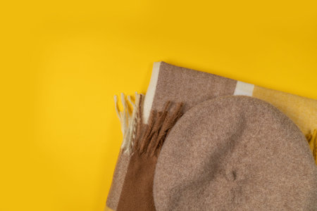 Woolen felt beret, yellow scarf on a bright yellow background. Fall shopping, autumn sale,...