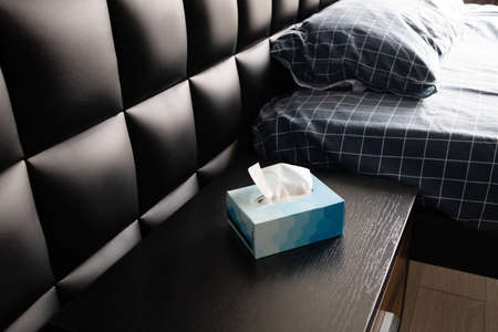 Close up of white tissue in blue paper box on the bedside table in the bedroomの写真素材