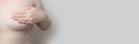 Close up of caucasian woman chest looking for signs of male breast cancer. Breast examination by herselfの写真素材