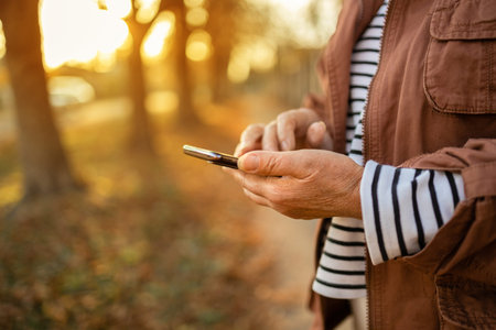 woman hand holding mobile cellphone, reading news or watching online having video call using mobile...