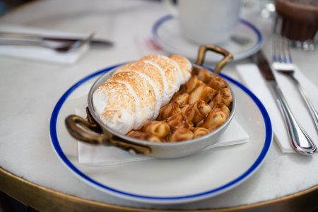 Plate of delicious mini pancakes with meringue cream and caramel