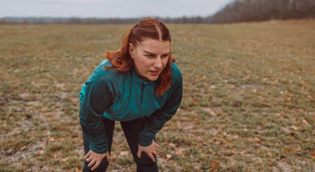 Portrait of tired fitness young woman outdoors after her fitness workout. Healthy lifestyle concept. Active sports peopleの写真素材