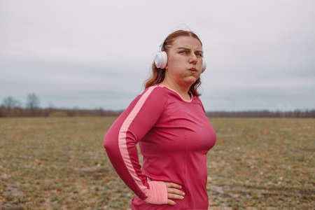 Portrait of tired fitness young woman outdoors after her fitness workout. Healthy lifestyle concept. Active sports peopleの写真素材