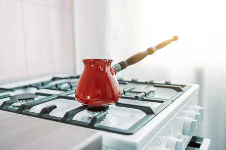 turkish metal cezve with handle on gas oven in kitchen. Morning routine