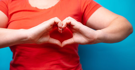 Hands making heart shape. love symbol over blue background. people affection and care concept
