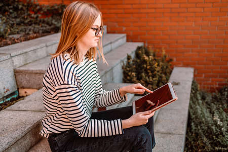 Happy woman using a digital tablet outdoorsの写真素材
