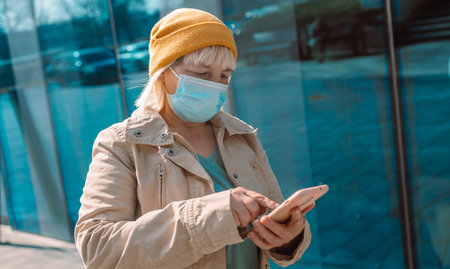 Close-up image of a womans hands using smartphone shows the direction of the path on the city street