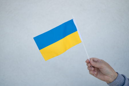 Happy European 30s woman holding a yellow and blue flag of Ukraine in outdoors.