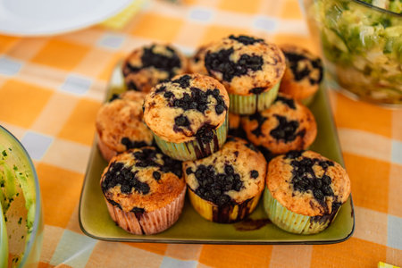 Sweet delicious berry cupcakes muffins in plate on color background. Copy space. Picnic at a local...