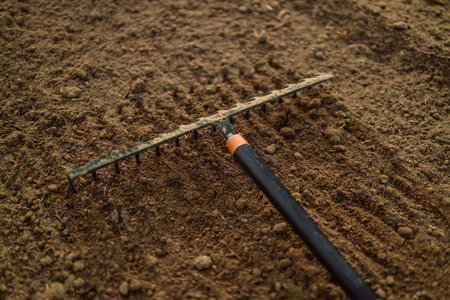 Cultivation of land by large garden rake. Spring cleaning. Selective focus.の写真素材