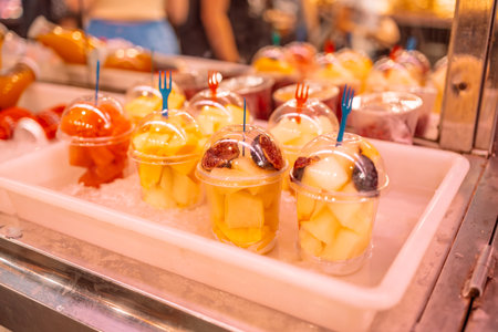 Juices and fresh packaged fruit, on the shelf of a greengrocery or on street market. Convenience, healthyの写真素材
