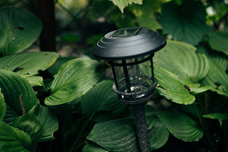 Solar cell lamp in garden and save energy of electric and save my world, close up. Charging solar lamp on the ground in the garden at sunny day, renewable energy concept.の写真素材