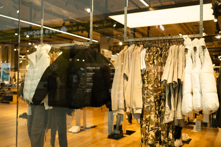 Men male casual clothes on shelves and hangers in a mall store. Stack of jackets in a mall store....