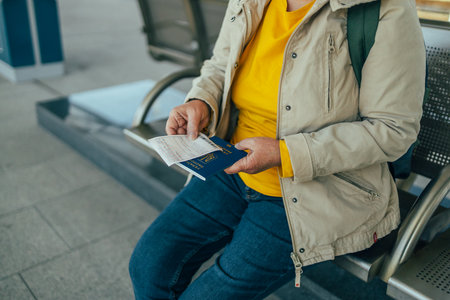Woman hand holding ticket and passport to train station. Travellng by airplane. Ticket documents for boarding plane train. Close-upの写真素材
