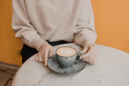 Make tiredness a thing of the past. Closeup shot of an unrecognizable woman having a cup of coffee at a cafe.の写真素材