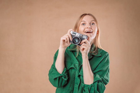 Young blonde girl holding vintage camera looking at the camera. love expression.の写真素材