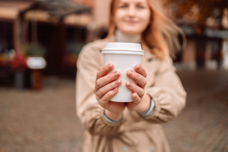 Portrait of happy nice woman drinks coffee while traveling in European old town enjoying cup of tea, coffee. Gdansk, Polandの写真素材