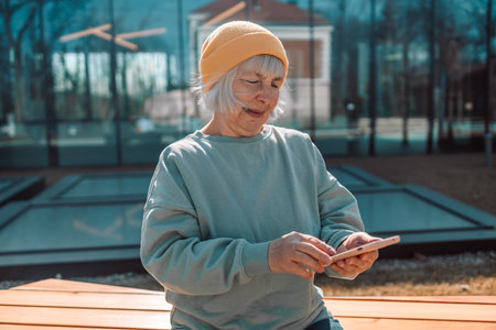 Middle age woman smiling happy and using smartphone at the city. High quality photoの写真素材