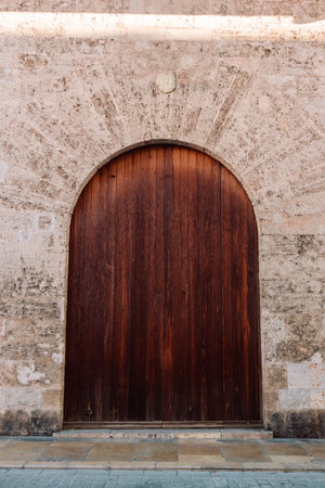 Ancient wooden door and stone gate in rays of sunlight of a architecture old town Valencia, Spainの写真素材