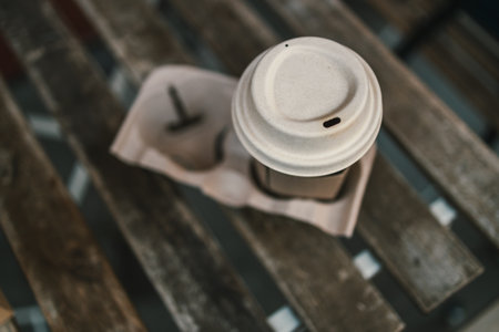 Cup of coffee to go on the wooden table with latte art. Street coffee, top view. High quality photoの写真素材