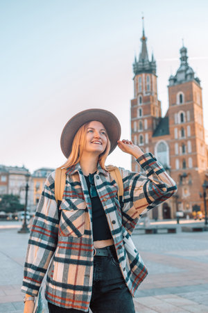 Traveler smiling exploring tourist woman in casual clothes hat hold paper map on Market Square in Krakow. Passenger travelの写真素材