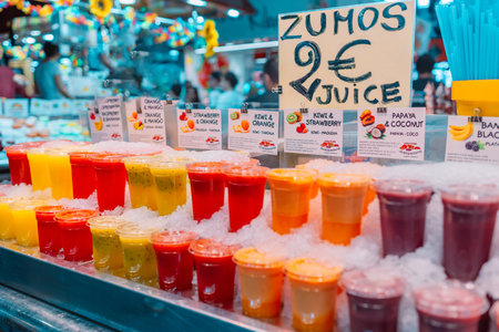 Colorful tropical fruit smoothie, fresh cold drinks with ice on street market shop stall, close up photo. High quality photoの写真素材