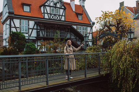 Outdoor smiling lifestyle portrait of pretty young woman having fun in the city in Europe. Gdansk,...