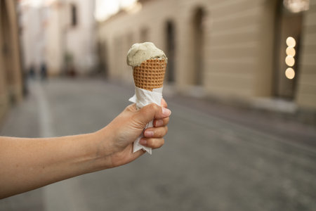 Happy young woman with delicious ice cream in waffle cone outdoors. Space for text. high quality photoの写真素材